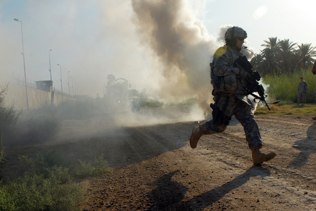 After popping a smoke grenade to signal where medevac helicopters should land, Sgt. James Wendling, a team leader from Mansfield, Ohio, assigned to D Troop, Division Special Troops Battalion, 1st Cavalry Division, runs to re-assure a simulated casualty during training at Camp Slayer, Baghdad, Sept. 22. The DSTB Soldiers, who are frequently outside the wire, were offered an opportunity to hone their skills by running through two different combat scenarios with their squads.